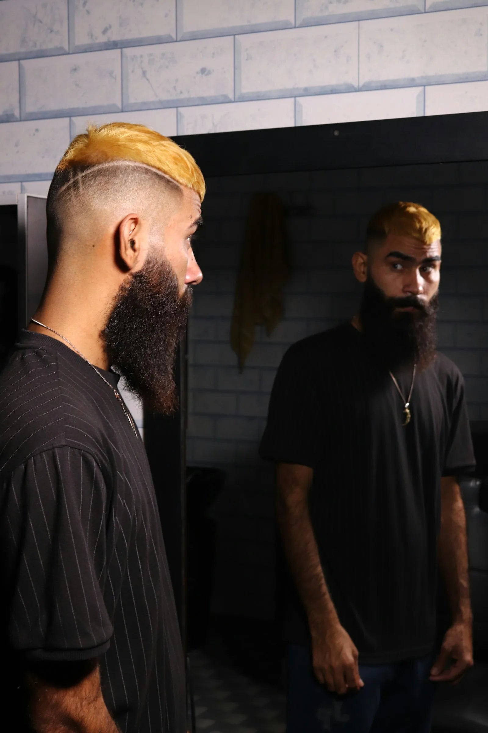 Bald man examining his hairline and reflection in a mirror, considering laser cap hair regrowth treatment options