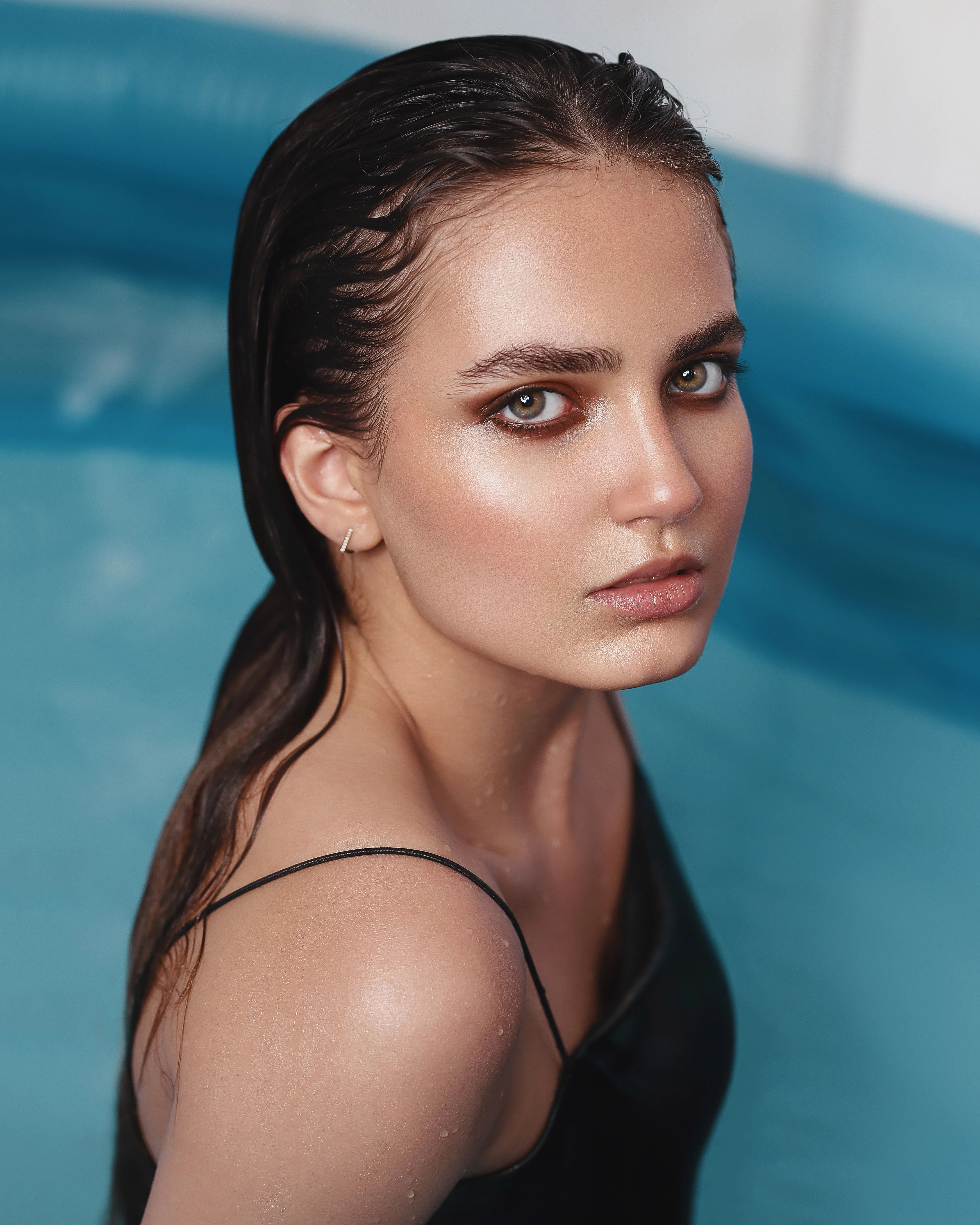 Woman with wet hair in a swimming pool, illustrating the effects of chlorinated water on hair