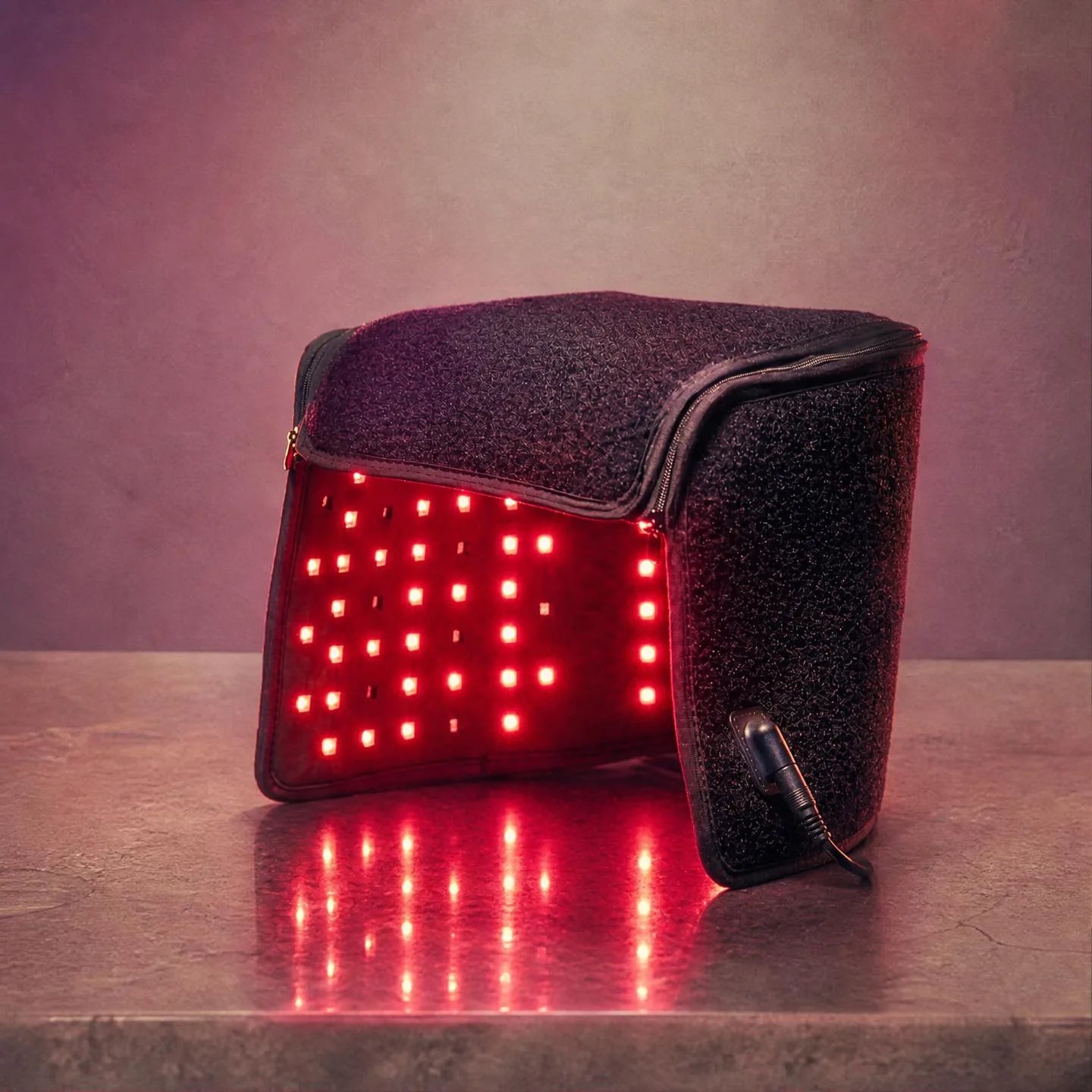 The cap's 660nm output, glowing red in a moody studio shot